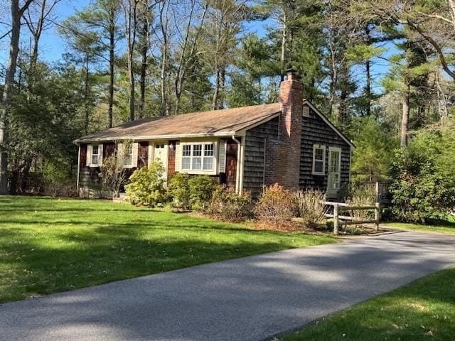 single story home featuring a chimney and a front yard