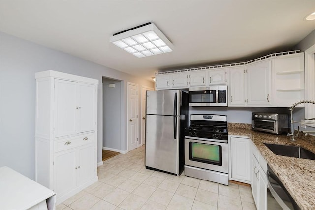 44 Spruce Tree Ln Unit 44, Norton, MA 02766 - kitchen with stainless steel appliances, light stone countertops, light tile patterned floors, white cabinetry, and open shelves