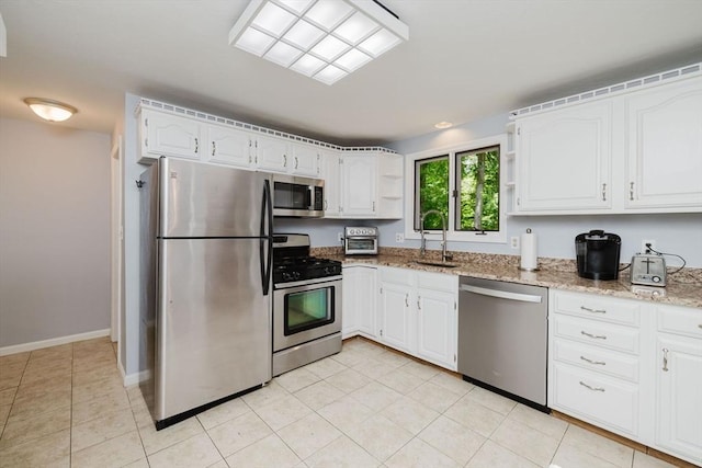 44 Spruce Tree Ln Unit 44, Norton, MA 02766 - kitchen with appliances with stainless steel finishes, open shelves, light stone countertops, white cabinetry, and light tile patterned floors