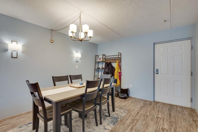 289 Elm St Unit 34B, Medford, MA 02155 - dining area featuring light wood-style floors, a chandelier, and a textured ceiling