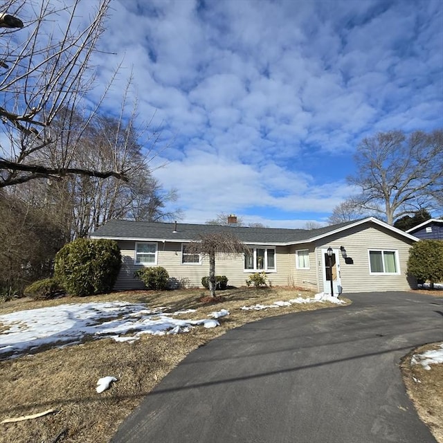 ranch-style home featuring aphalt driveway