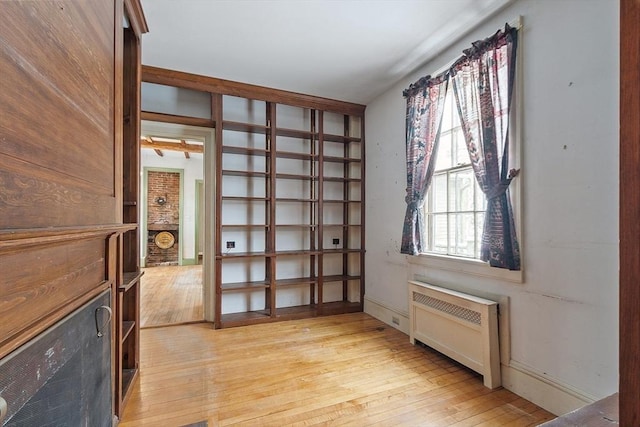 interior space featuring radiator heating unit and light hardwood / wood-style floors