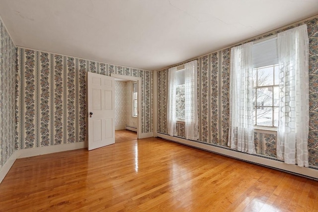 spare room featuring hardwood / wood-style flooring and a baseboard radiator