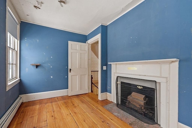 unfurnished living room featuring crown molding, light wood-type flooring, and baseboard heating