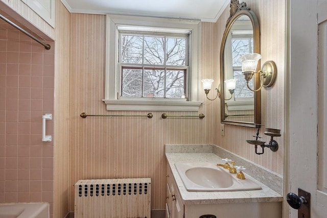 bathroom with vanity, a tub, and radiator