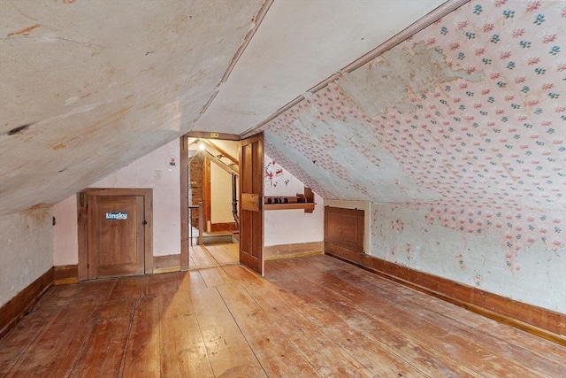 additional living space with lofted ceiling and light hardwood / wood-style floors