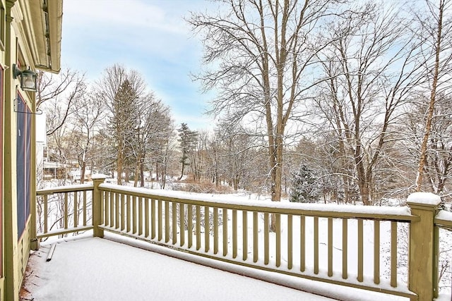 view of snow covered back of property