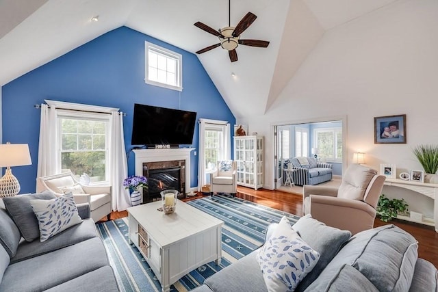 living room featuring wood-type flooring, high vaulted ceiling, ceiling fan, and a healthy amount of sunlight