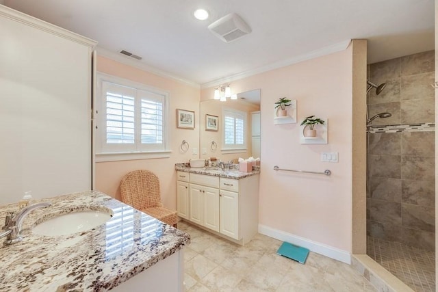 bathroom with vanity, ornamental molding, and tiled shower