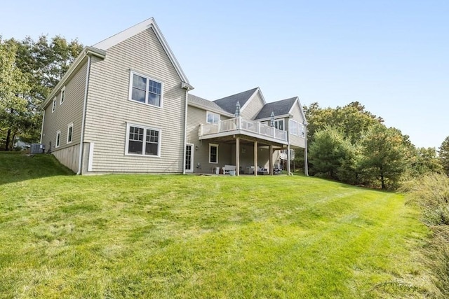 rear view of property with a yard, cooling unit, and a deck