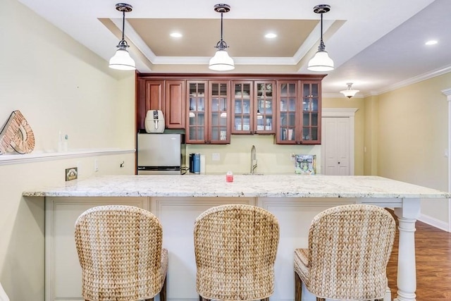 kitchen featuring a kitchen breakfast bar, kitchen peninsula, and white refrigerator