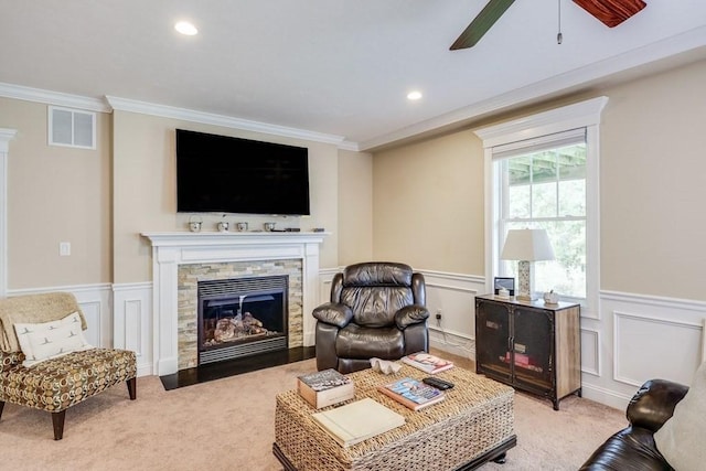 carpeted living room featuring a stone fireplace and ornamental molding