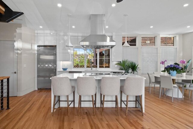 142 Amory St Unit 2, Cambridge, MA 02139 - kitchen featuring stainless steel built in refrigerator, island exhaust hood, white cabinets, light countertops, and recessed lighting