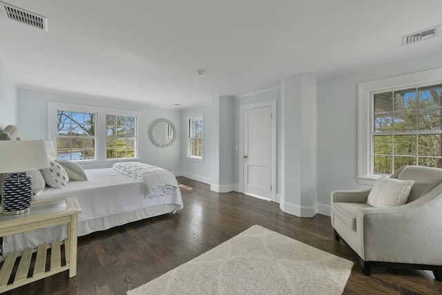 bedroom featuring wood finished floors, visible vents, and baseboards