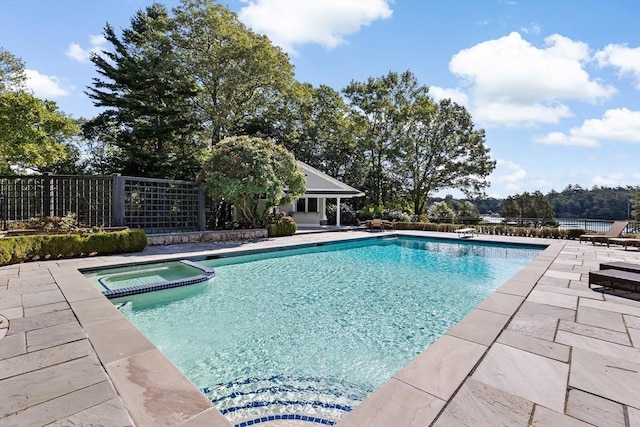 view of pool with a patio area, fence, and a pool with connected hot tub