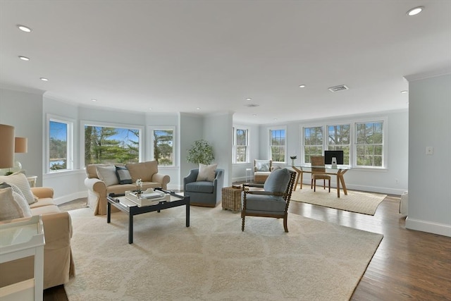 living area with visible vents, a healthy amount of sunlight, and crown molding