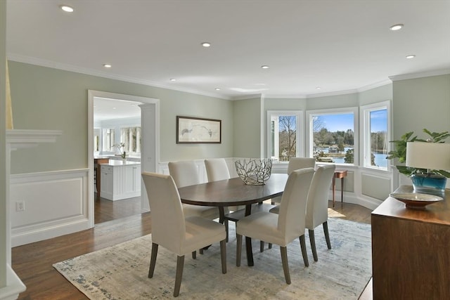 dining room featuring wainscoting, ornamental molding, and wood finished floors