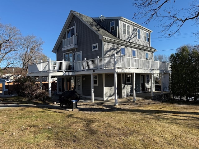 back of property with a lawn and a wooden deck