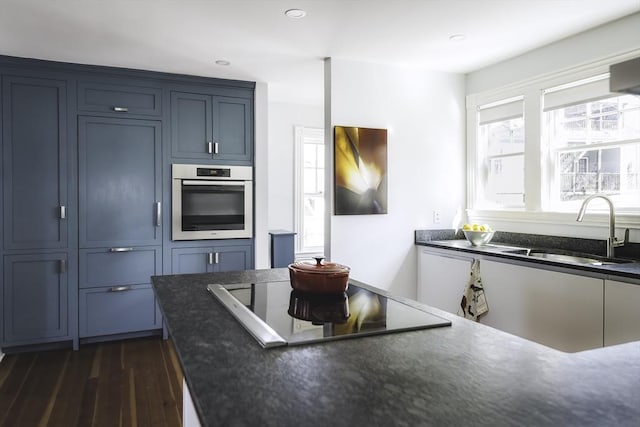 kitchen featuring a sink, black electric cooktop, stainless steel oven, recessed lighting, and dark wood-style floors
