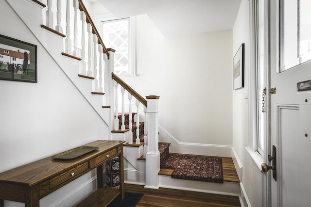 entrance foyer with baseboards, wood finished floors, a healthy amount of sunlight, and stairway