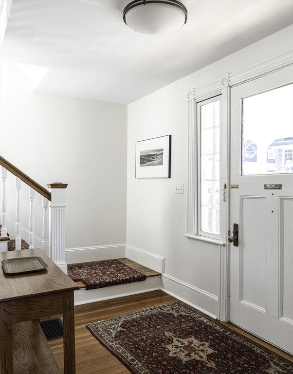 entrance foyer featuring baseboards, wood finished floors, a wealth of natural light, and stairway