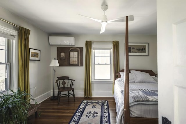 bedroom featuring baseboards, a wall unit AC, a ceiling fan, and dark wood finished floors