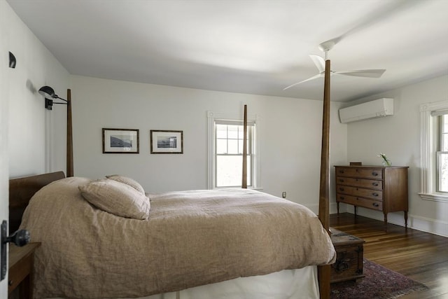 bedroom with a ceiling fan, baseboards, a wall mounted AC, and wood finished floors