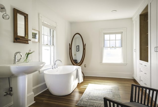 bathroom featuring baseboards, plenty of natural light, and wood finished floors