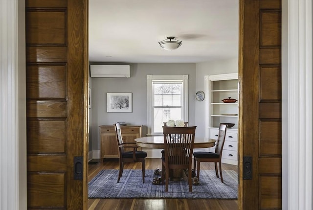 dining space featuring dark wood finished floors and a wall mounted AC