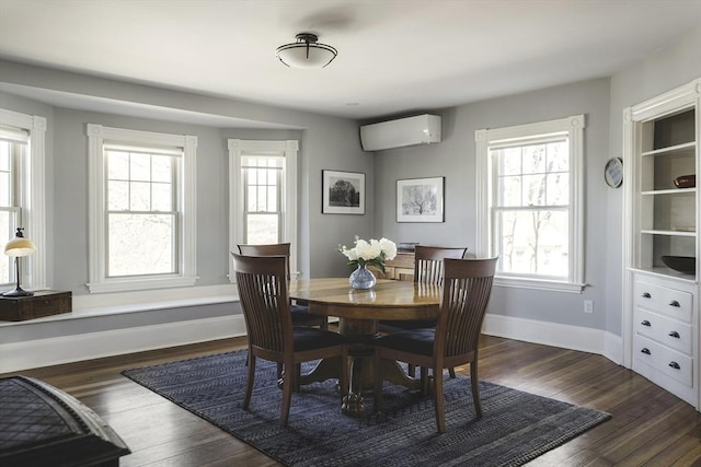 dining room featuring baseboards, a wall mounted AC, and dark wood-style floors