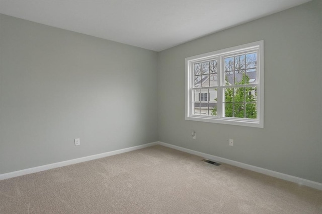 unfurnished room with baseboards and light colored carpet