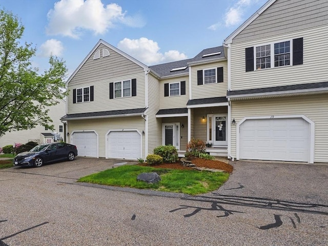 multi unit property with a garage and asphalt driveway