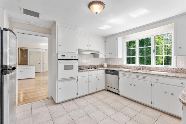64 Bakers Hill Rd, Weston, MA 02493 - kitchen with stainless steel appliances, under cabinet range hood, decorative backsplash, and white cabinets