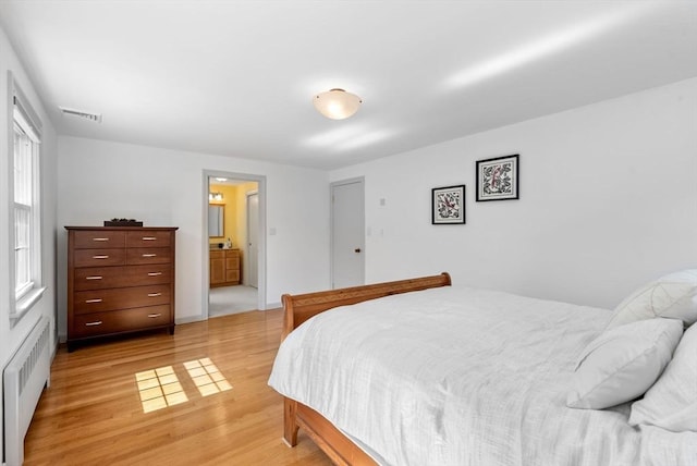 64 Bakers Hill Rd, Weston, MA 02493 - bedroom with radiator heating unit, light wood-style floors, and ensuite bath