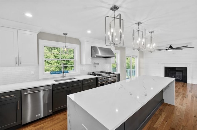 320 Old Westport Rd, Dartmouth, MA 02747 - kitchen with appliances with stainless steel finishes, wall chimney exhaust hood, plenty of natural light, a large island, and recessed lighting