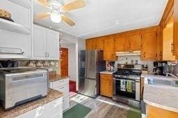 kitchen featuring sink, light wood-type flooring, stainless steel appliances, and ceiling fan