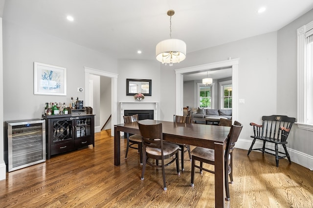 dining room featuring an inviting chandelier, beverage cooler, and hardwood / wood-style floors