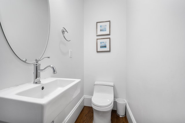 bathroom featuring hardwood / wood-style flooring, sink, and toilet