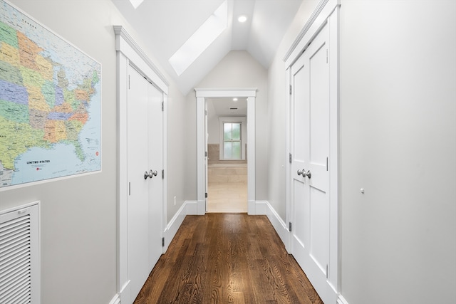 hallway with vaulted ceiling with skylight and dark wood-type flooring