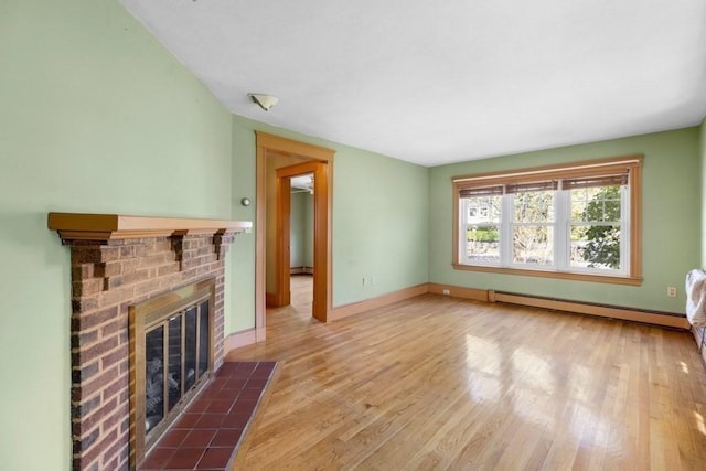 unfurnished living room featuring baseboards, a brick fireplace, wood finished floors, and baseboard heating