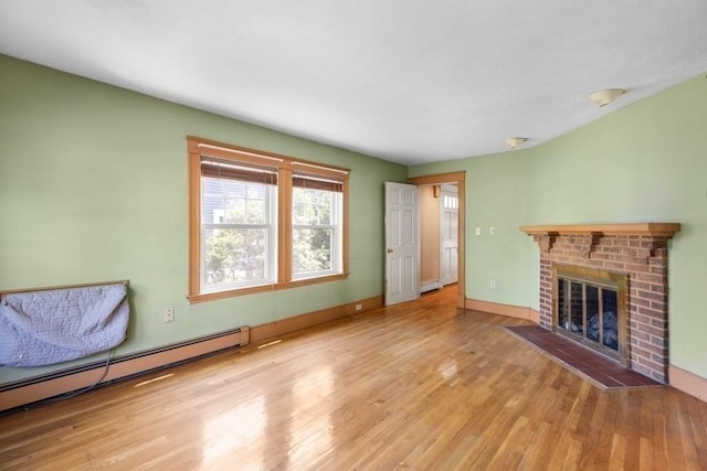 unfurnished living room featuring baseboards, a fireplace, a baseboard heating unit, and wood finished floors