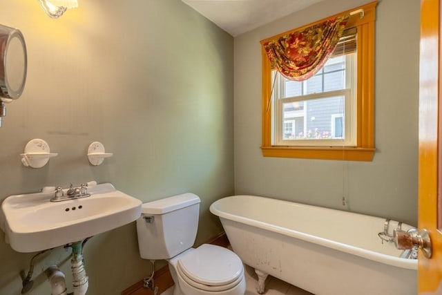 full bath featuring toilet and a freestanding tub