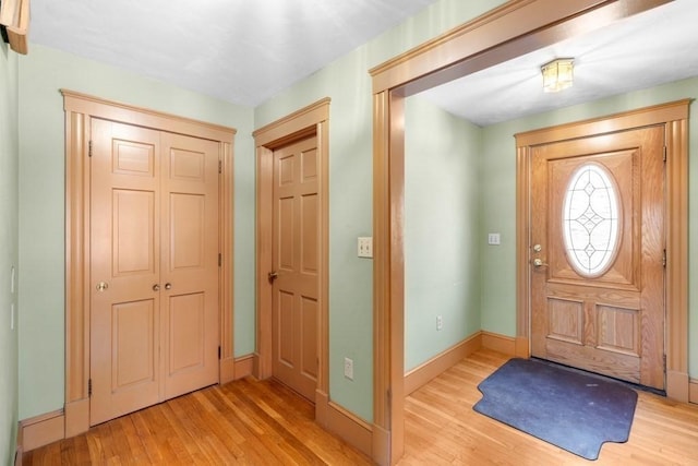 foyer with baseboards and wood finished floors