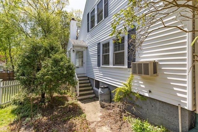 view of property exterior with fence and entry steps