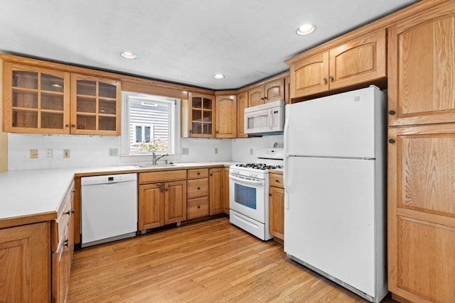 kitchen with recessed lighting, light wood finished floors, white appliances, and glass insert cabinets