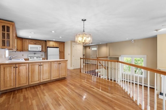 kitchen featuring a sink, a chandelier, glass insert cabinets, white appliances, and light wood-style flooring