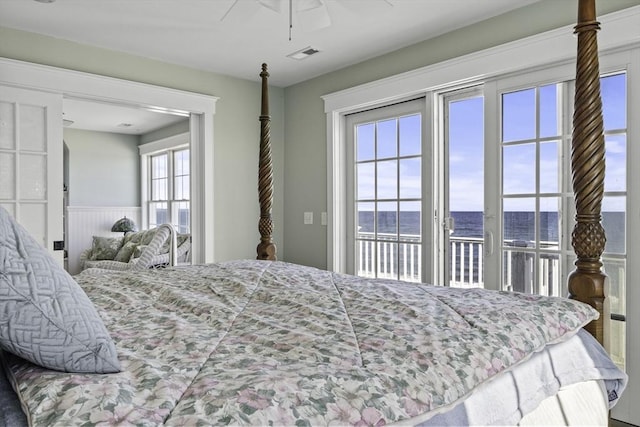 bedroom with access to exterior, a water view, and ceiling fan