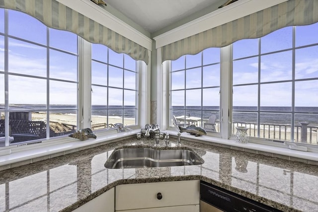 kitchen featuring white cabinets, a water view, dishwashing machine, and sink