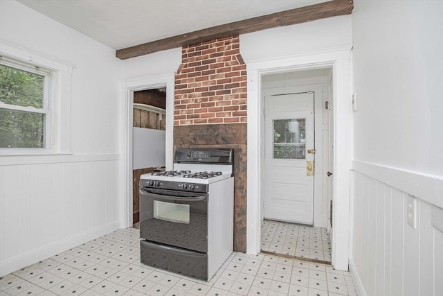 108 Arlington Rd, Woburn, MA 01801 - kitchen with white gas range oven, a wainscoted wall, and light floors