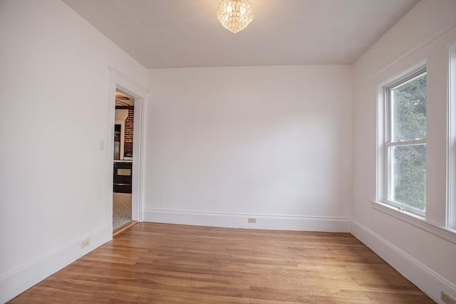 108 Arlington Rd, Woburn, MA 01801 - unfurnished room featuring healthy amount of natural light, light wood-style flooring, and a chandelier